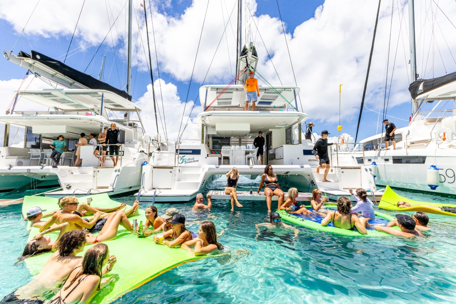 Voyage 590 stern platform raft-up with guests in the water