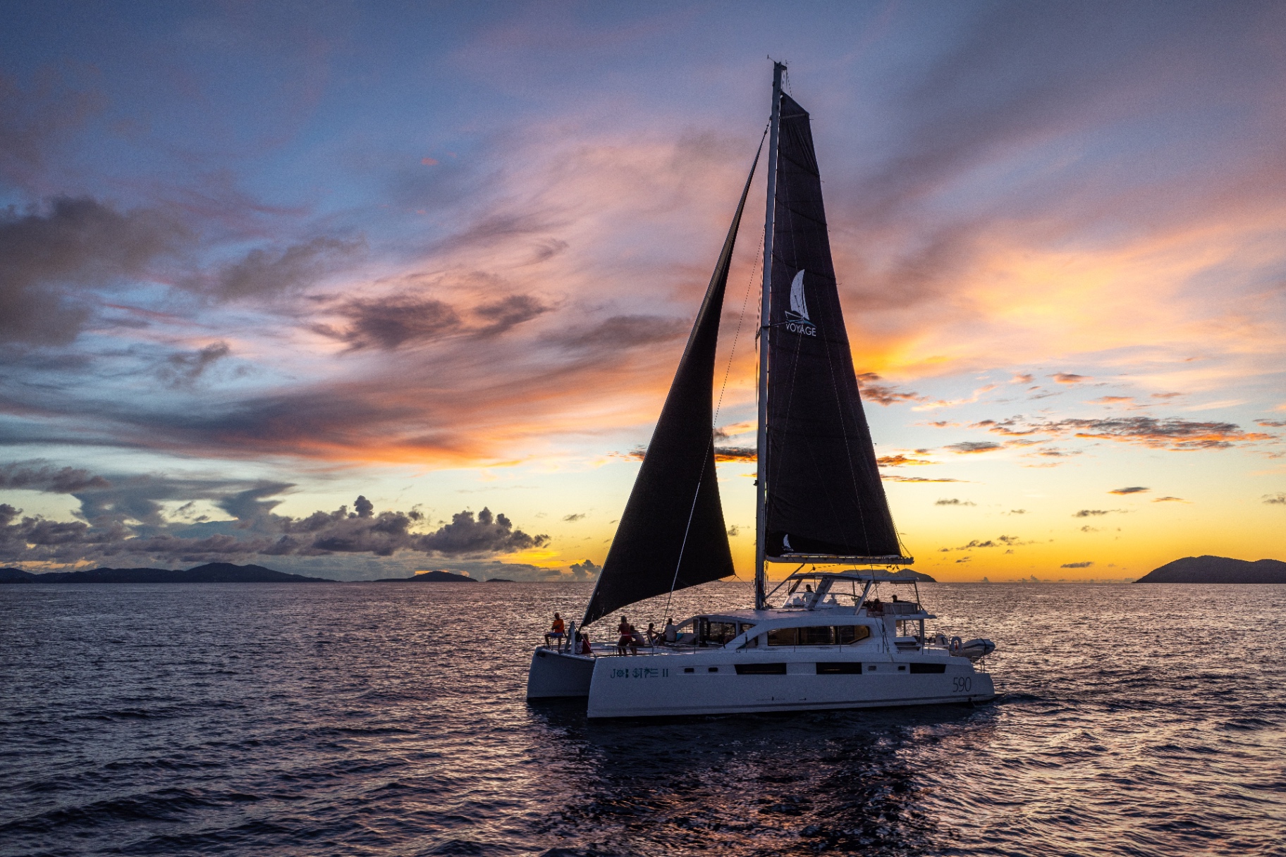 Voyage 590 under sail at sunset
